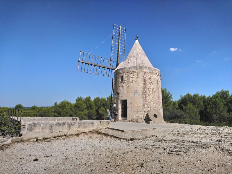 De son vrai nom le Moulin Ribet, il fut également appelé le Moulin Saint-Pierre.<br /><br />Il fut construit en 1814 et broya du blé pendant un siècle puisqu’il arrêta de fonctionner en 1915. La grande guerre fit que l’on réquisitionna à la fois les hommes et le blé, ce qui signa définitivement l’arrêt de mort du dernier moulin de Fontvieille.<br />En 1935 l’association des &quot;Amis d’Alphonse Daudet&quot; décida de le remettre en état et de créer en même temps un musée consacré à l’auteur des Lettres de mon Moulin.