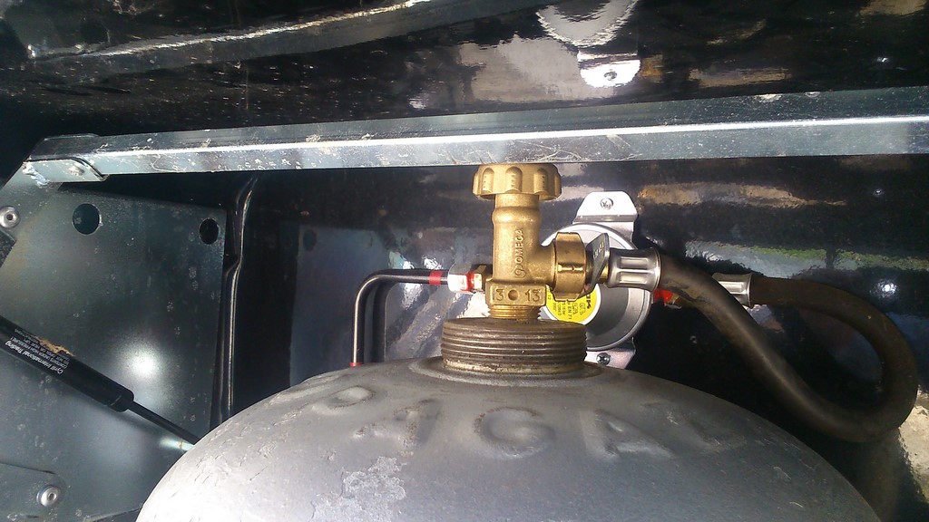 le robinet de fermeture passe tout juste.<br />Il faut coucher la bouteille sur le coté pour passer le robinet derrière la barre du haut.