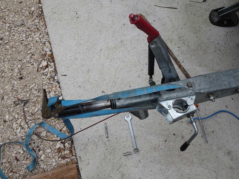 Sangle à cliquet pour enfoncer la tige de l'amortisseur.